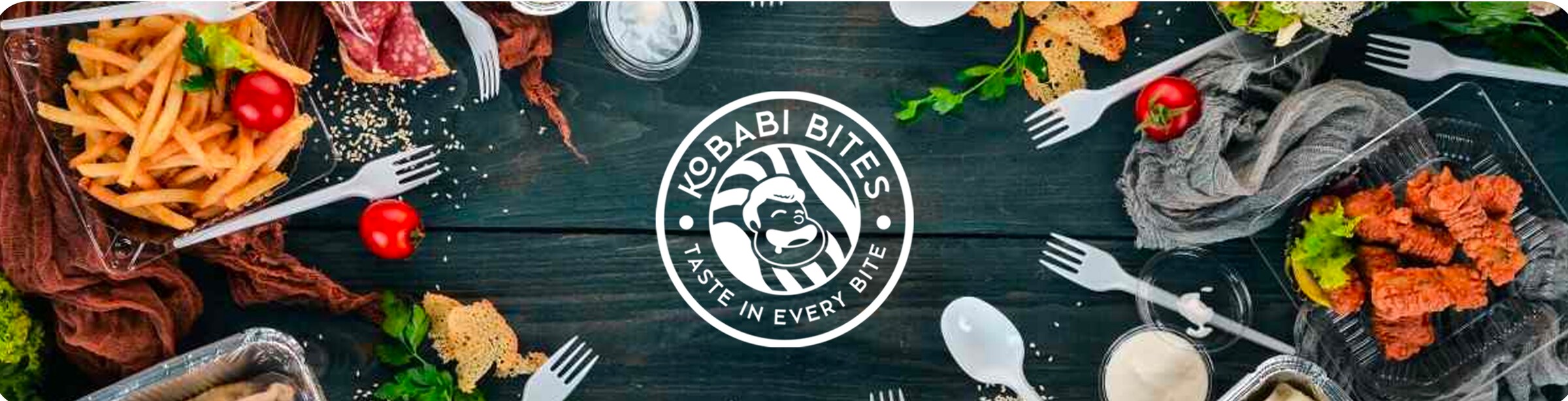 Table laid with fries, tandoori pieces and sides around the Kobabi Bites mark