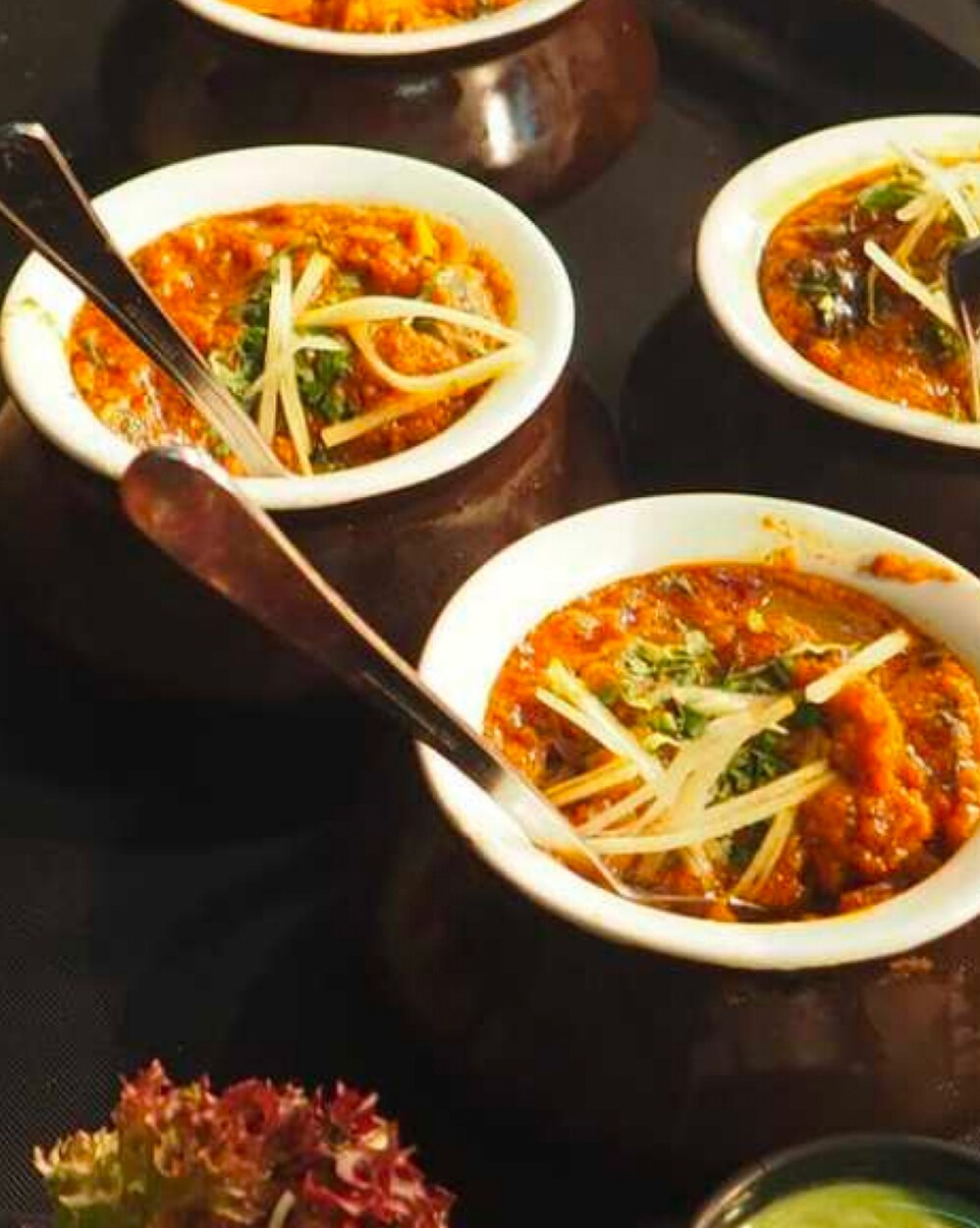 Bowls of North Indian gravy topped with ginger juliennes