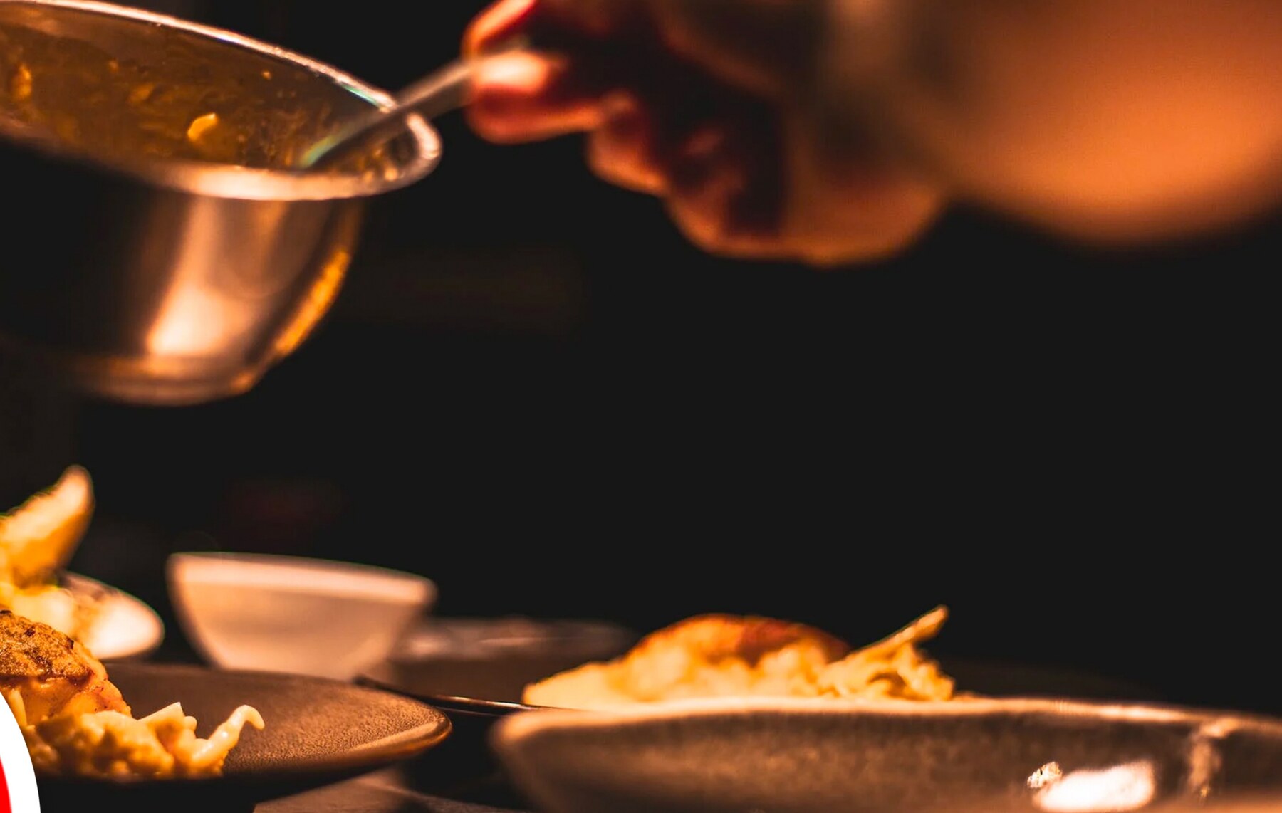 A dish being finished with sauce in the Kobabi kitchen